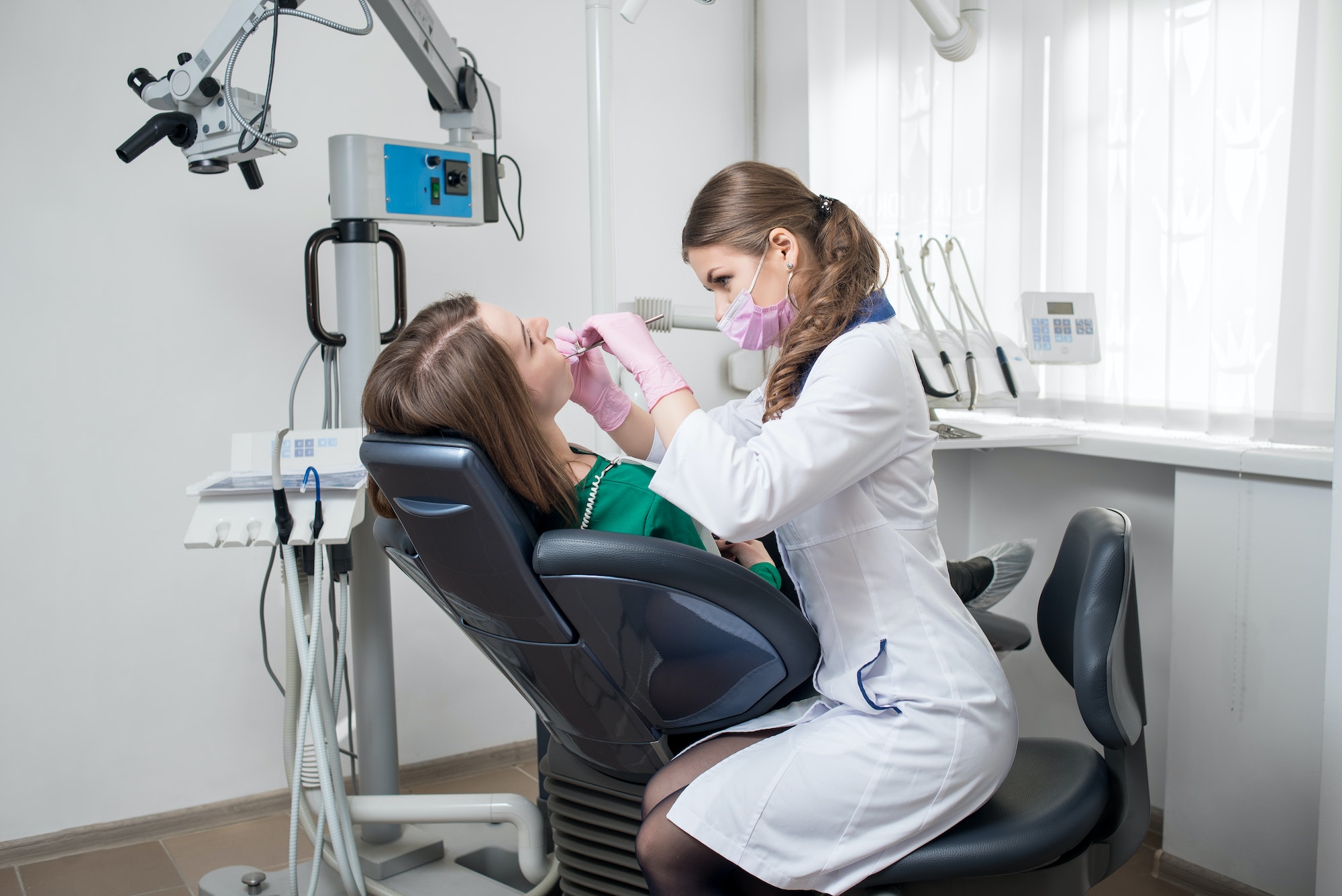 dentist-with-dental-tools-mirror-and-probe-checking-up-patient-teeth-at-dental-clinic-office.jpg