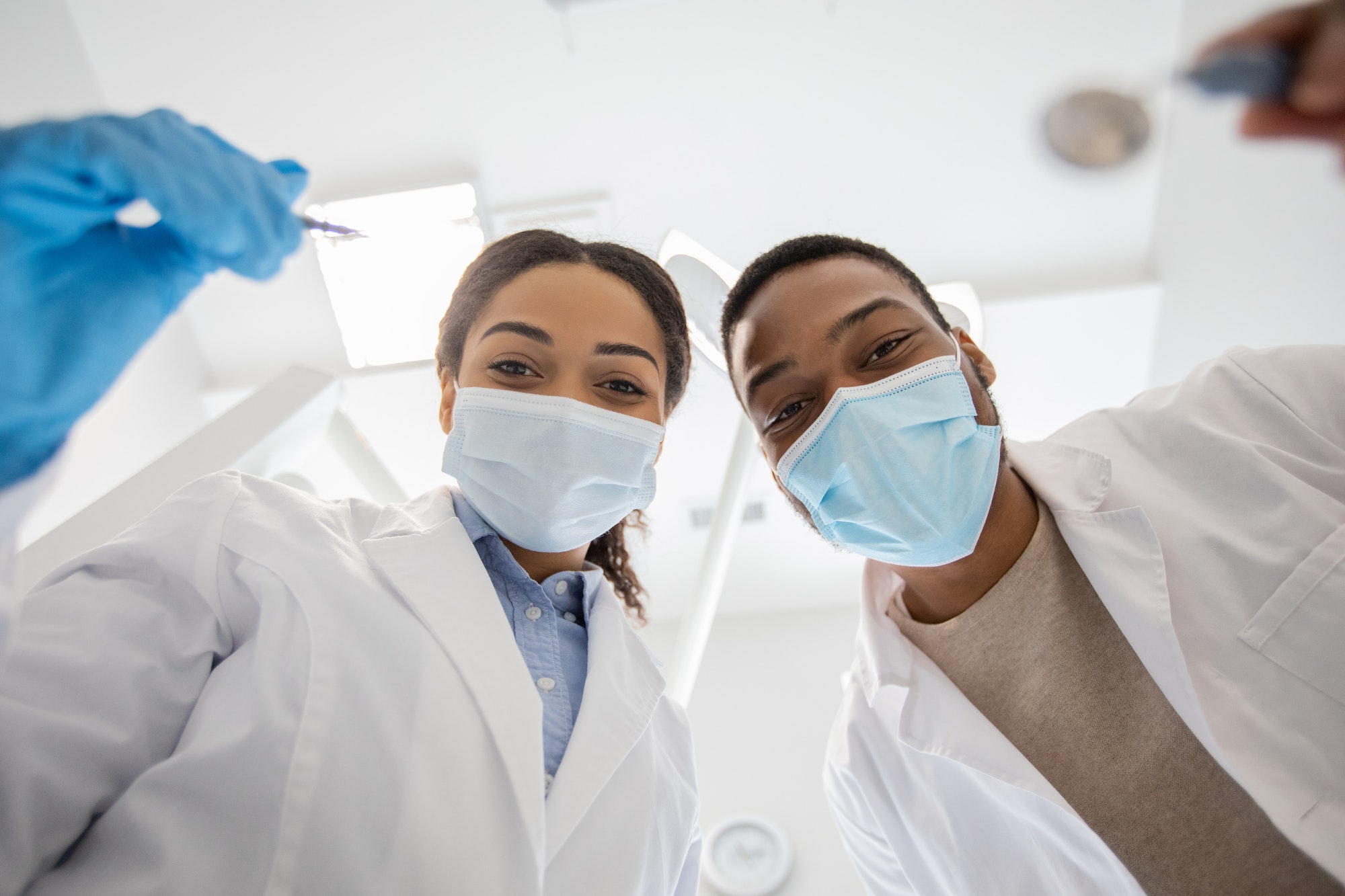 black-dentist-doctor-and-his-female-assistant-examinating-patients-teeth-low-angle.jpg